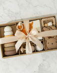 Gift set with baby toys and a bow on a marble surface