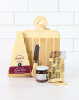 Artisan cheese board gift set with Italian cheese wedge, fig pear honey spread, crackers and bamboo serving board on white marble background