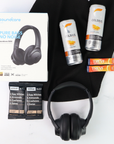 Black headphones, Celsius energy drink cans, and protein bars on a white background